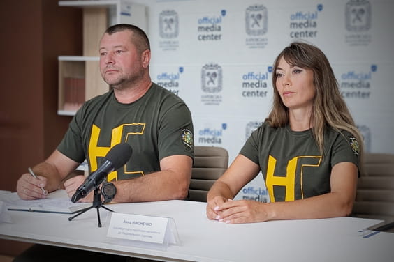 На фото сидять чоловік та жінка за столом