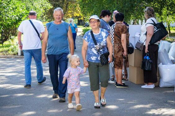 На фото родина йде по тротуару